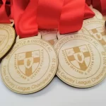 Five wooden medals with red ribbons.
