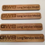 Three wooden signs with the words long service metal.