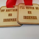 Two wooden medals that say my brother will never be an ironman.
