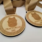 Four wooden medals with a ribbon on them.