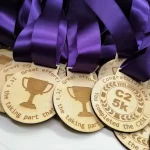 A group of wooden medals with purple ribbons.