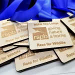A group of blue ribbons with the words rspb giving a home to wildlife.