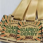 Eco-friendly soapbox derby medals with ribbons.