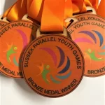 A group of medals with orange ribbons on them.