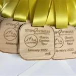 Five wooden medals with yellow ribbons.