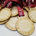 A group of wooden medals with ribbons on them.