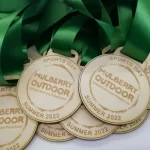A group of medals with green ribbons.