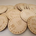 A bunch of wooden coasters with designs on them.