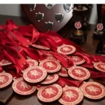 Eco friendly trophies and medals on a table with red ribbons.
