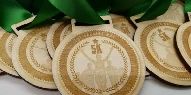 A collection of eco-friendly wooden medals adorned with green ribbons.