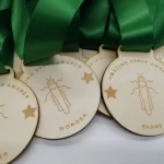 Five wooden medals with green ribbons.