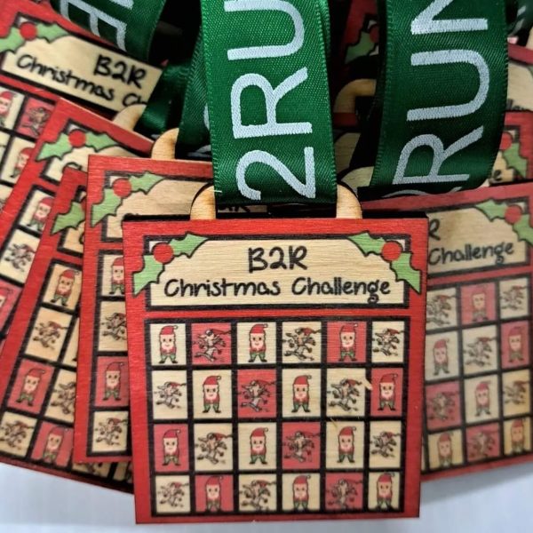 A collection of colorful Christmas challenge medals displayed on a table.