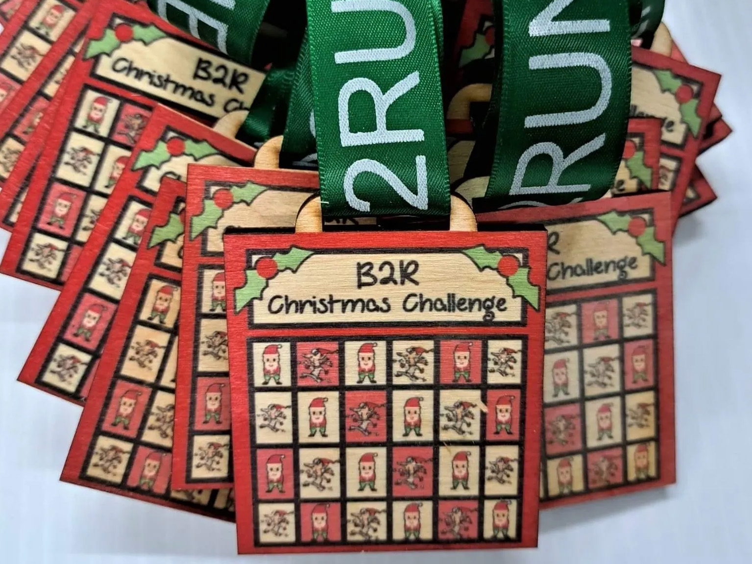 A collection of colorful Christmas challenge medals displayed on a table.
