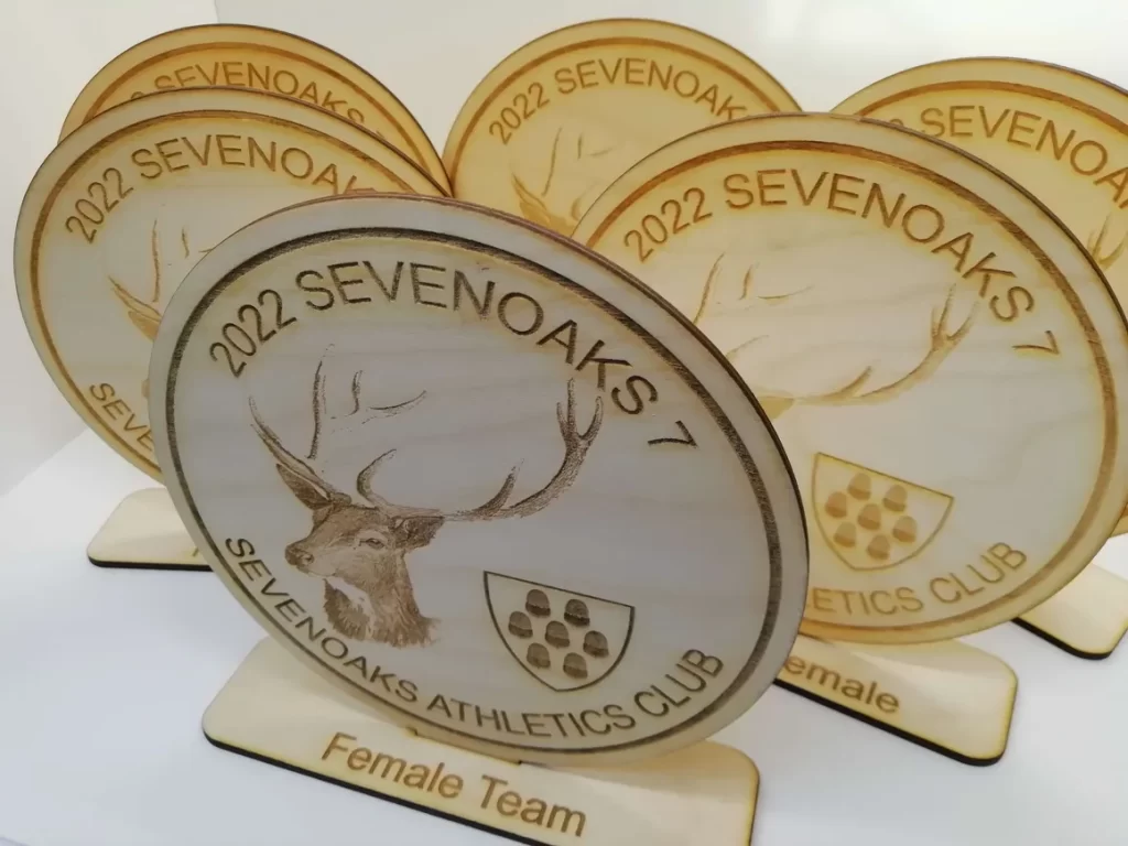 A set of sustainable wooden trophies with a deer on them.