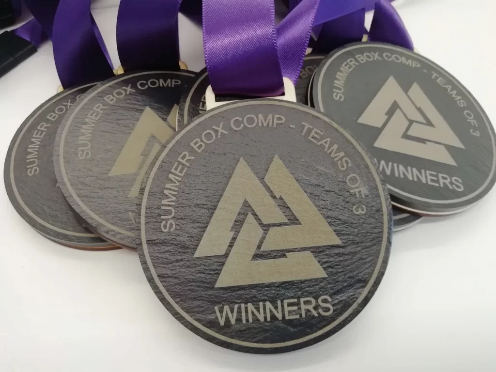 A group of medals with purple ribbons made from eco-friendly slate.