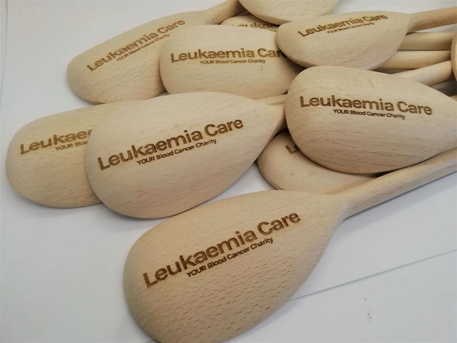 A group of sustainable wooden spoons with the words lukenin care on them, perfect to be used as trophies.