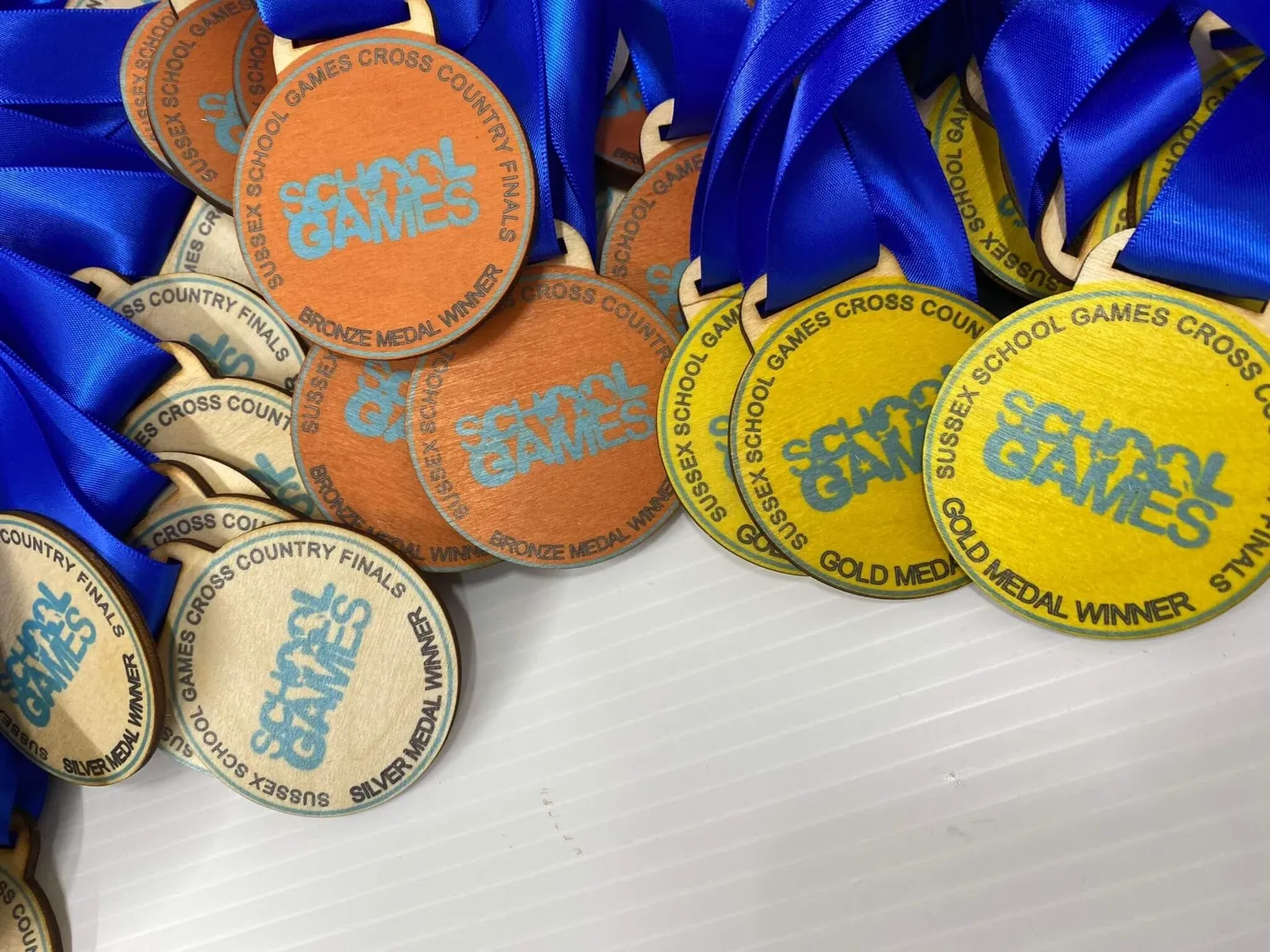 A collection of colourful medals featuring vibrant blue ribbons.