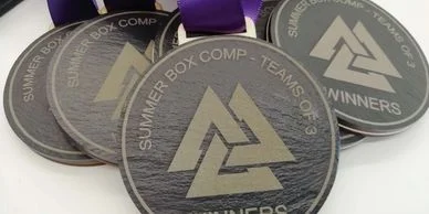 A group of custom medals with purple ribbons on them.
