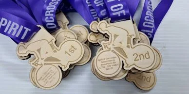 Custom wooden medals with a purple ribbon.