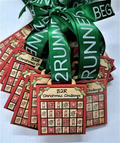 A group of Christmas gift tags with green ribbons featuring Santa Run Medals.