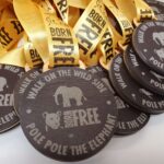 A group of medals with the words walk the wild free pole the elephant.