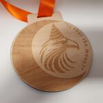 A wooden medal with an eagle on it.