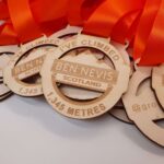 A group of wooden medals with orange ribbons.