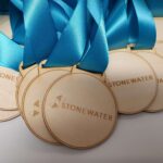 A group of wooden medals with blue ribbons.