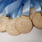 A group of wooden medals with blue ribbons.