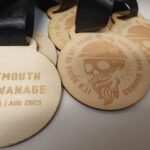 A group of wooden medals with the words weymouth and swanee.