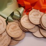 A group of wooden medals with ribbons on them.