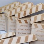 A set of wooden clappers with the words acting for film.