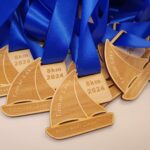 A group of wooden medals with blue ribbons.