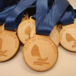 A group of wooden medals with blue ribbons.