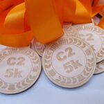 Five wooden medals with orange ribbons.