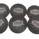 A set of black coasters with a logo on them.