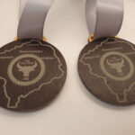 Close-up of two medals with an engraved map and text including "Bridgenorth" and "The Bull Ring." The medals hang from white ribbons.