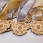 Wooden medals with ribbons read "West Coast Best Coast 2024" with 1st, 2nd, and 3rd place inscriptions.