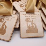 Wooden medals with gold ribbons display "2024 Summerwalk 48KM Route" and a silhouette design.