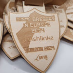 Wooden shields with engraved text: "Best Dressed in Europe 2024," "unishlinkz," "London 2024," "Lov uk.