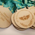 Wooden medals with teal and yellow ribbons, engraved with "16th Buccleuch Property Challenge" and "Friday 6th September 2024.