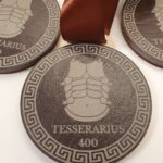 Brown medal with the word "TESSERARIUS" and number "400" engraved, featuring an illustration of armor. Brown ribbon attached.