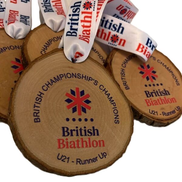 Wooden round medals with “British Biathlon British Championships Champions U21 – Runner-up” printed on them, each attached to a white ribbon with the British Biathlon logo and text.