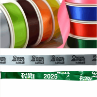 Multiple spools of colourful ribbons, including sustainable medal ribbons, a silver ribbon with Royal Air Force netball text, and a green ribbon with Traffic Trail 2025 text are displayed.