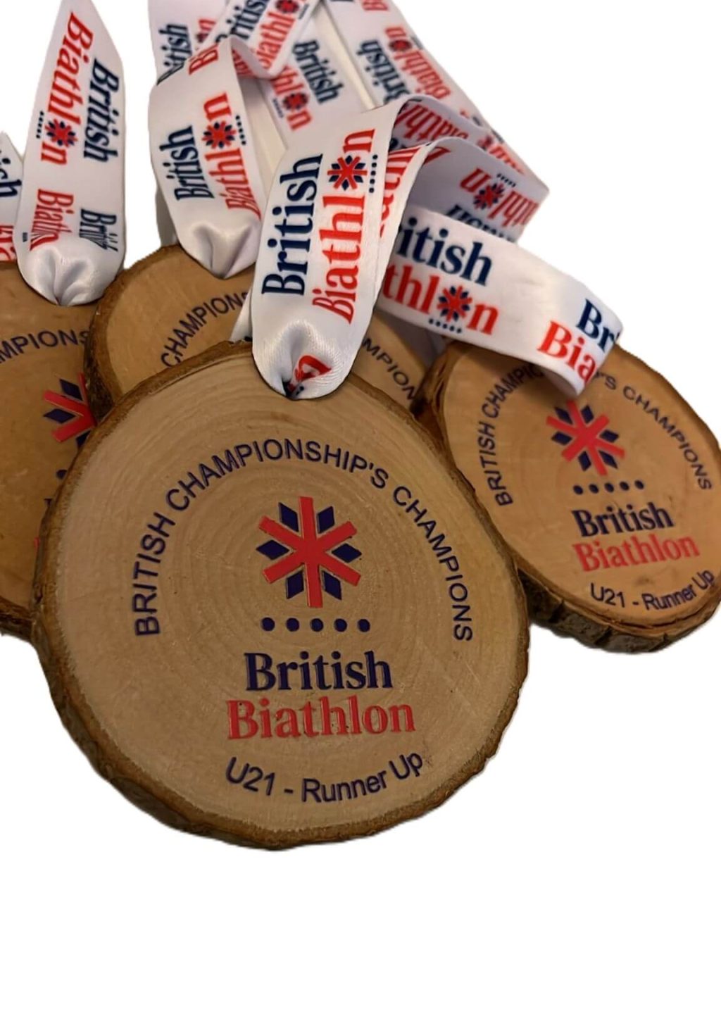 Wooden round medals with “British Biathlon British Championships Champions U21 – Runner-up” printed on them, each attached to a white ribbon with the British Biathlon logo and text.